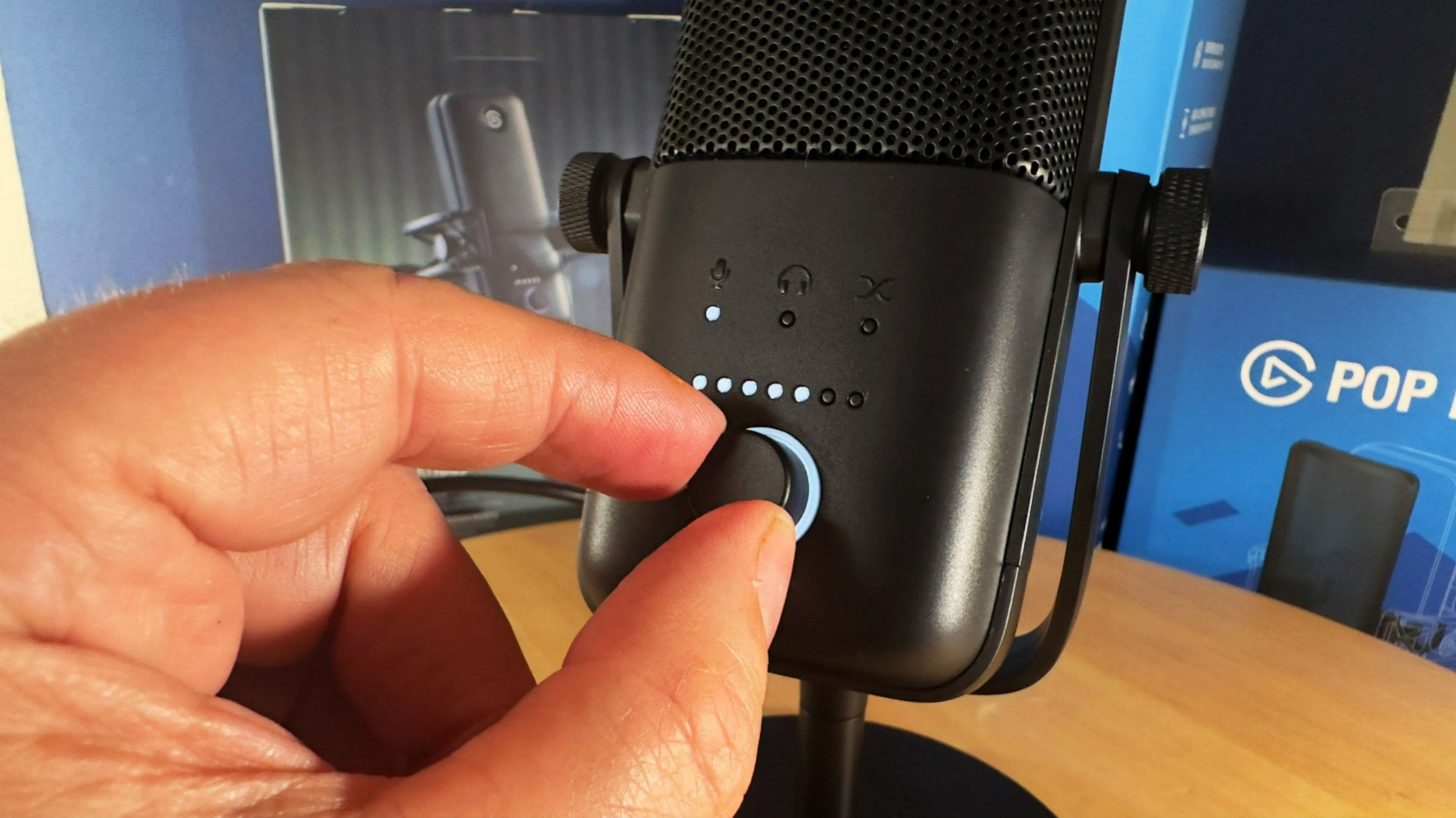Elgato Wave:3 review image showing someone adjusting a dial on the microphone.