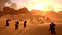 Helldivers 2 - four helldivers holding guns walking across a desert towards a group of eneimes