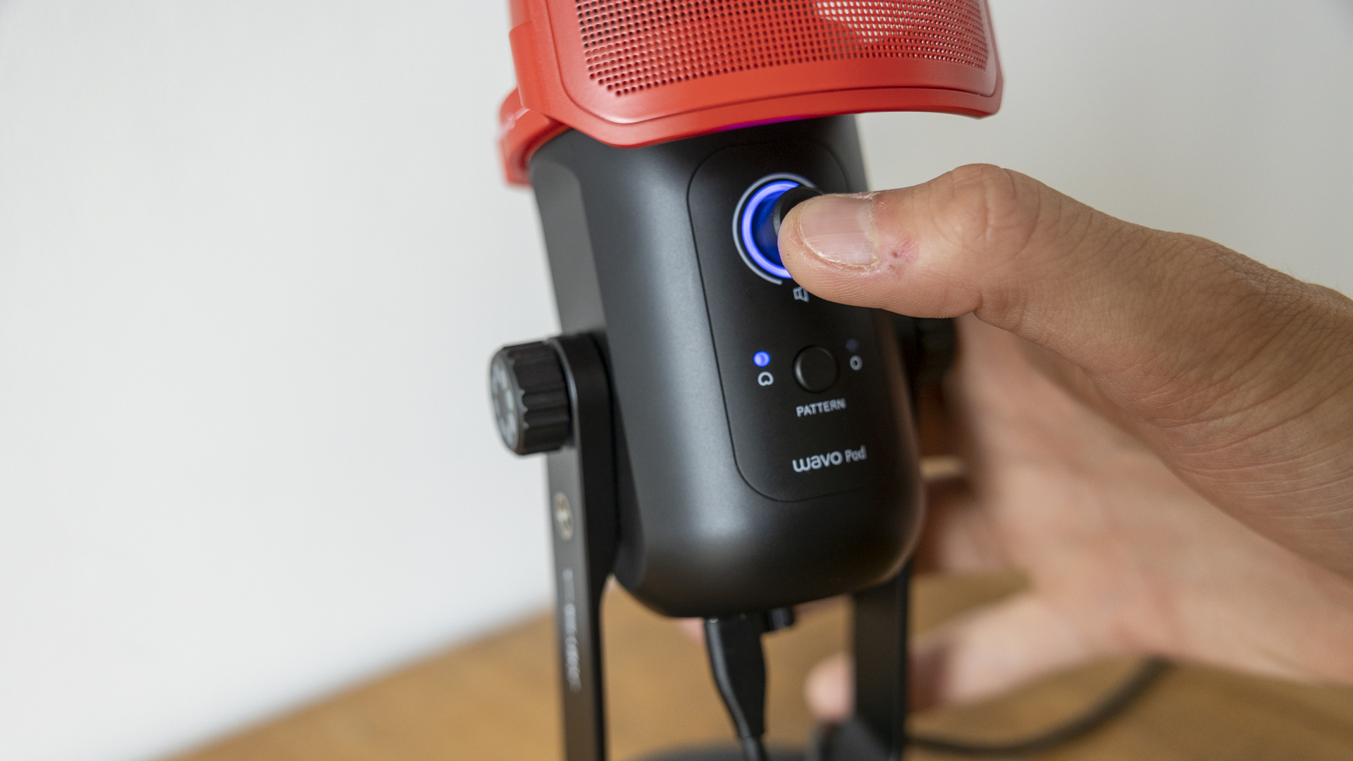 Joby Wavo Pod review image showing a person pressing a button on the microphone