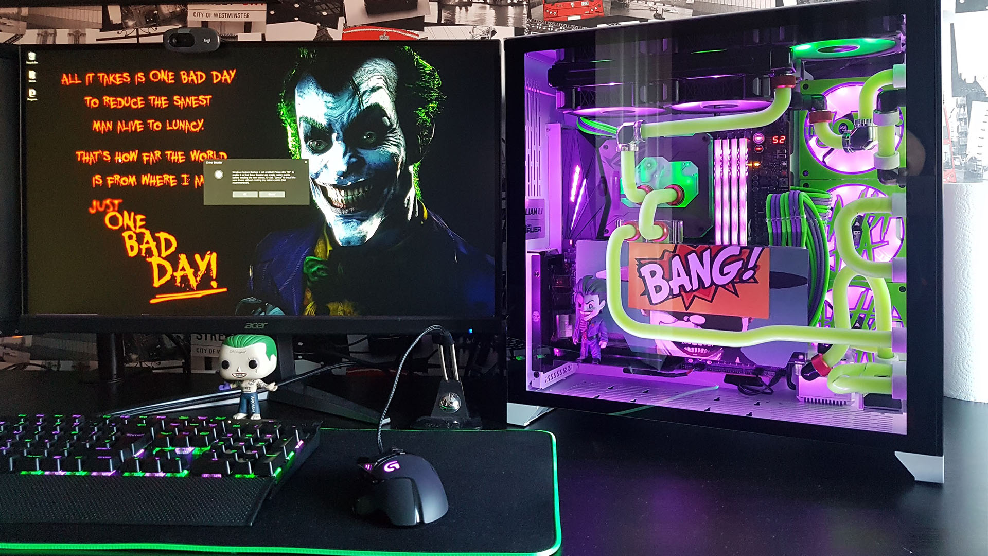 The joker gaming PCm build next to a monitor with a joker background