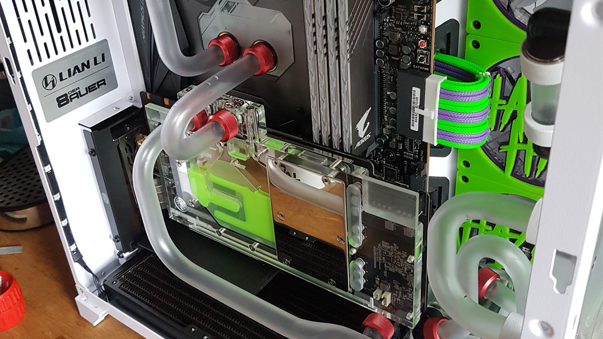 The distro plate and green cables inside the joker themed gaming pc