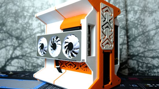 An orange and white gaming PC, which has been entirely 3D printed, holds a white and silver GPU