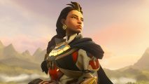 All new Overwatch 2 heroes will be free, no battle pass needed: A woman of colour with long black hair wearing silver and gold armor with a golden chestplate looks over her shoulder in a mountain area