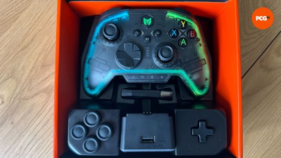 The Rainbow Pro 2 controller in it's box with additional thumbsticks, d-pad and the charging dock 