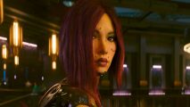 Cyberpunk 2077 director new content: a woman with dark red hair looks back at the camera