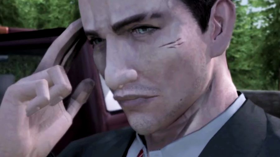Deadly Premonition: The Director's Cut - Francis York Morgan, a clean-cut FBI agent in a suit with a small scar under his left eye, holds two fingers to his ear as if talking over a bluetooth earpiece.