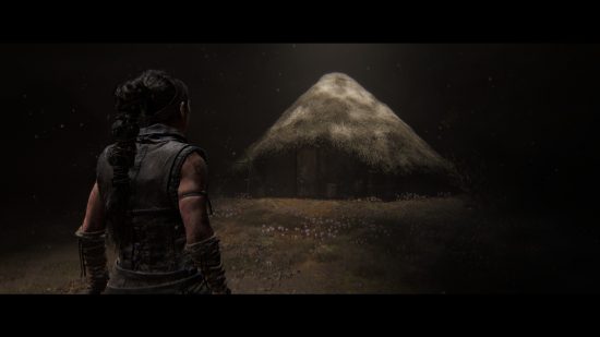 Hellblade 2 preview: Senua approaches her childhood home in her mindscape, a small hut surrounded by flowers.