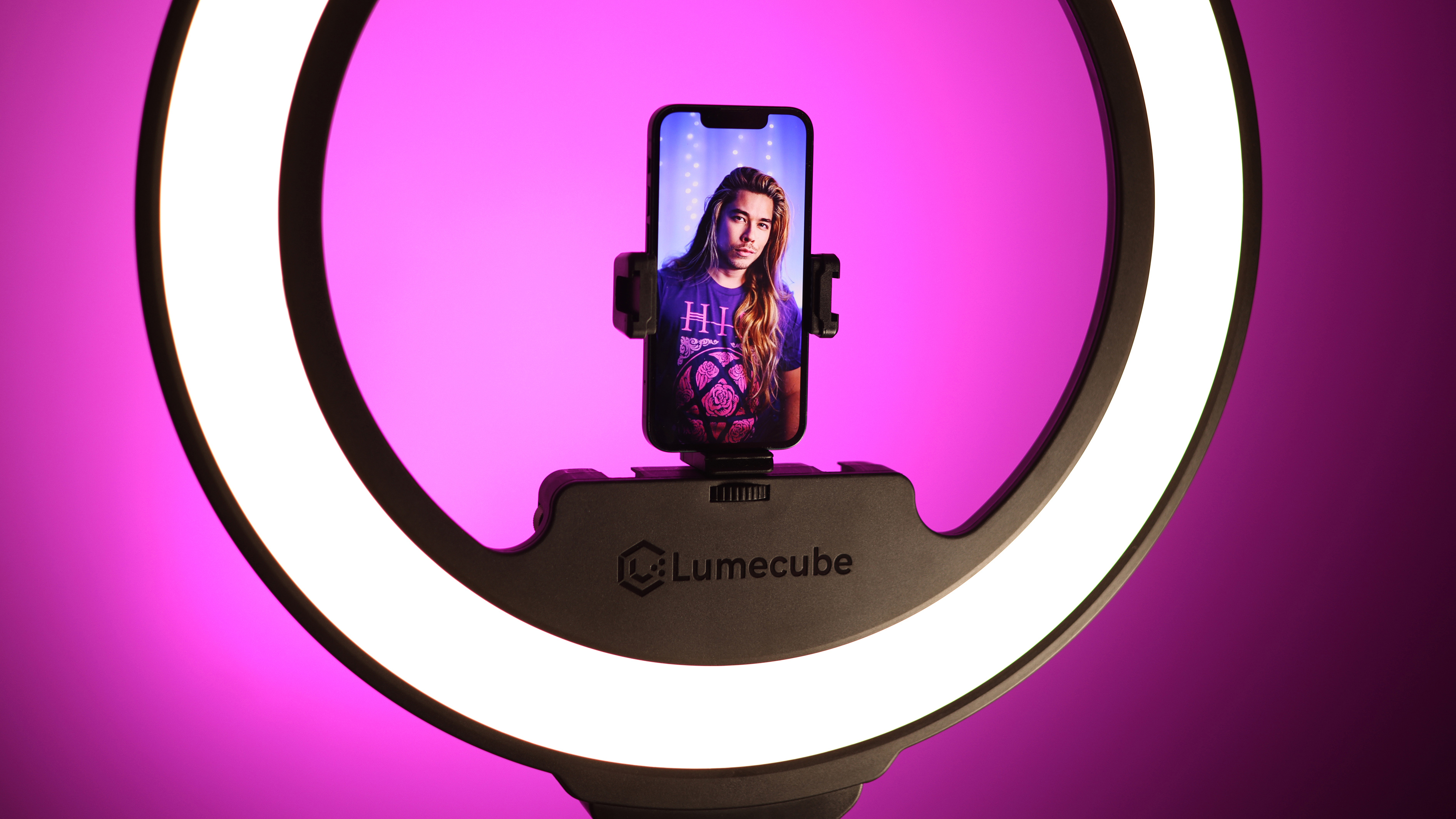 Lume Cube Ring Light Pro review image showing a phone clamped in place in the light, with a zoom in showing the photographer seen through the lens of the camera with the light shining on them.