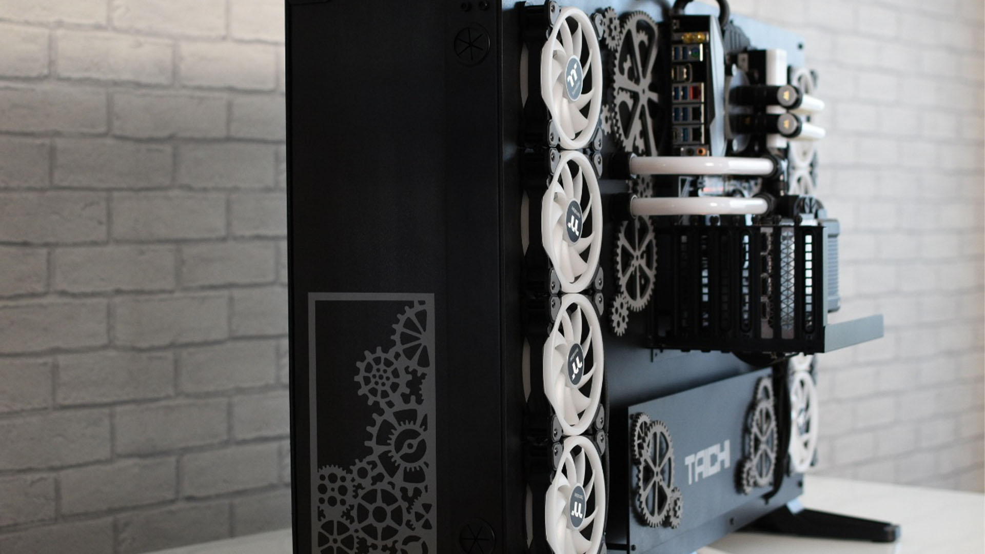 The side profile of the Project Taichi gaming PC build with black edges and white cogs