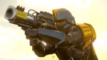 Helldivers 2 patch delay: a man in black and yellow armor holding up a giant cannon