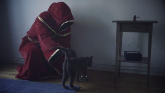 A sad wizard in a red robe strokes a gray cat in a depressing modern apartment.