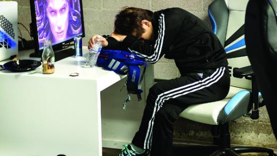 A StarCraft pro slumps in his chair next to a monitor after losing his series in WCS Season 3 America.