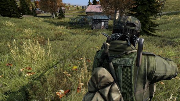 A man aims his gun down a grassy hill in DayZ, one of the best survival games.