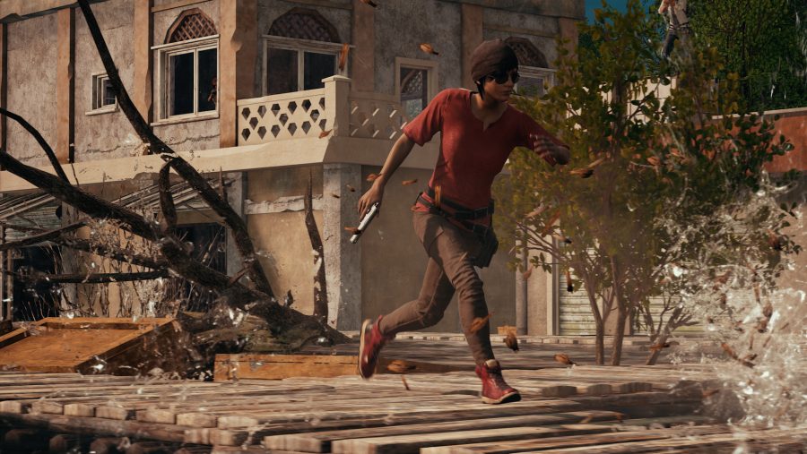 A player runs across the rooftops in PUBG, in Fortnite vs PUBG