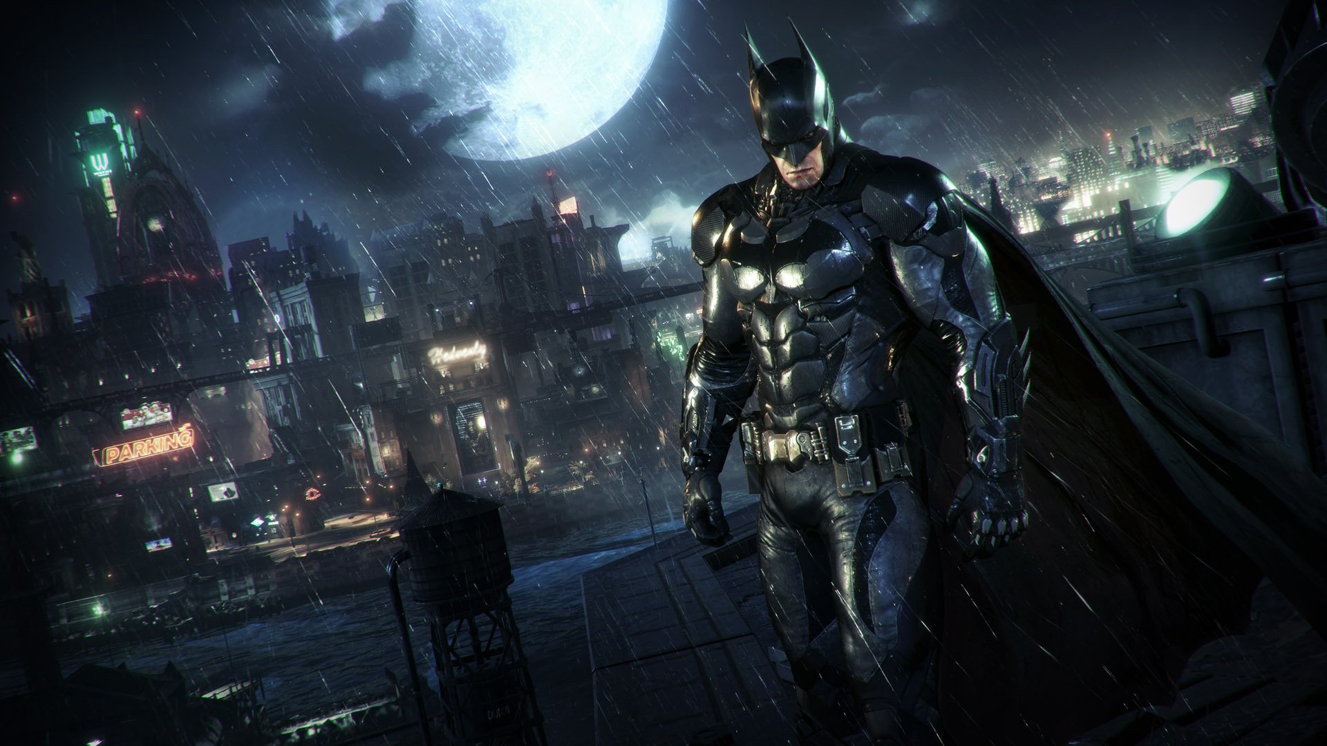Best open world games: Batman in Batman: Arkham Knight is standing on a rooftop in the rain, looking very serious.