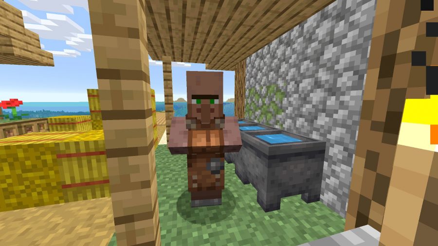 Un villageois forgeron dans Minecraft.  Il se tient à côté de trémies remplies d'eau et de foin.