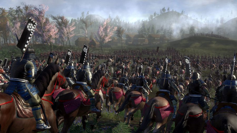 Enemies charging into battle on horseback. The two sides have not yet clashed in the field just outside a small settlement. Some trees in the background are blossoming.
