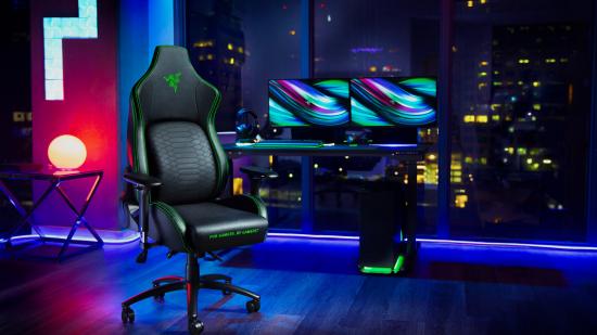 The Razer Iskur gaming chair sits in front of a dual monitor setup against RGB lighting