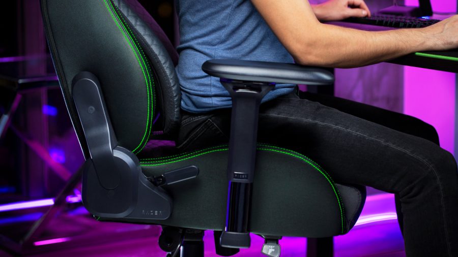 A man sits on the Razer Iskur gaming chair while playing games