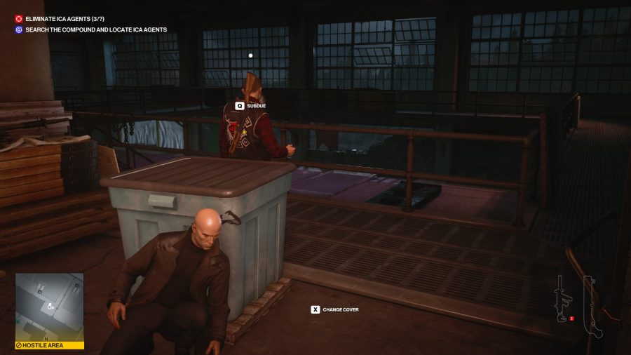 Agent 47 hiding behind a blue container, waiting to ambush his target