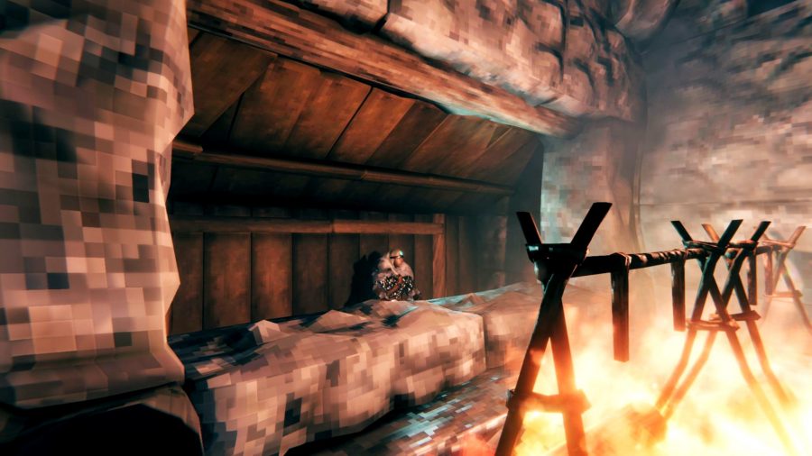 A Viking woman sits by a cooking station in Valheim