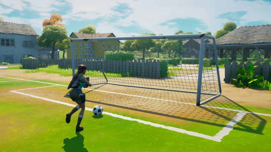 Lara Croft is about to score a goal in Pleasant Park in Fortnite.