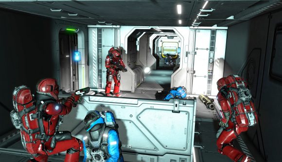 Three red coloured men in space suits and weapons hold a corridor, the bodies of blue team around them.
