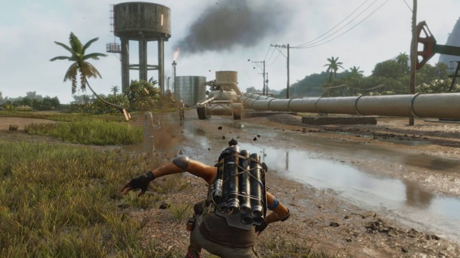 Player character Dani Rojas crouches to fire a barrage of mortar shots from the Exterminador, a supremo weapon in Far Cry 6. Their target is a tank, which approaches menacingly on the horizon between a water tower and an oil pipeline