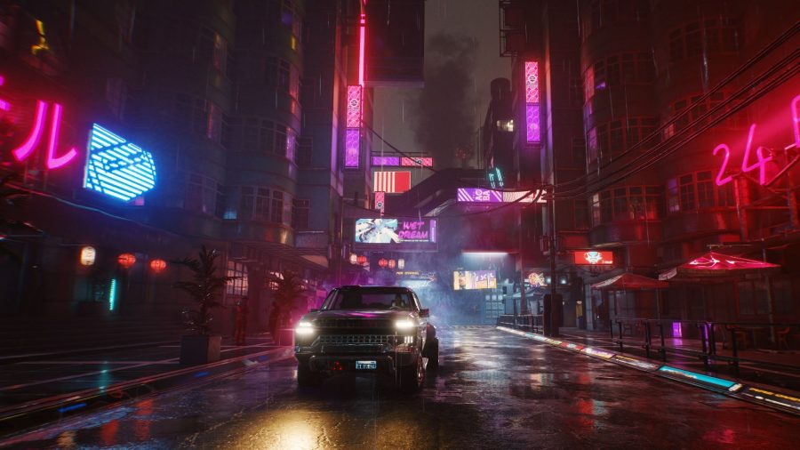 A truck driving through the quiet streets of Night City in Cyberpunk 2077