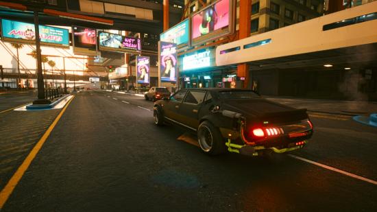 V's car heads down a Night City street at dusk in Cyberpunk 2077.