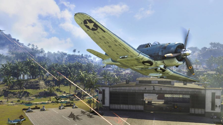 A plane is flying close to a hangar, being shot at by an AA gun in the Caldera map in Warzone.