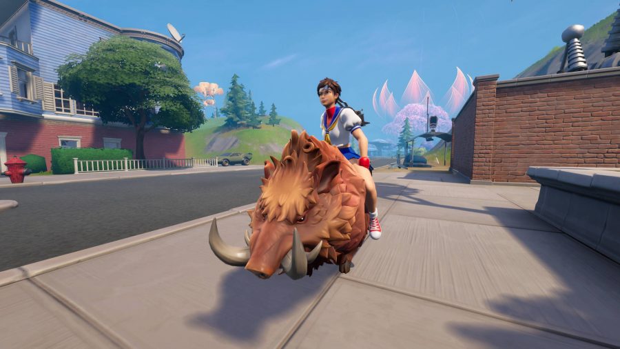How to ride Fortnite animals: Sakura from Street Fighter is riding a boar down a street.