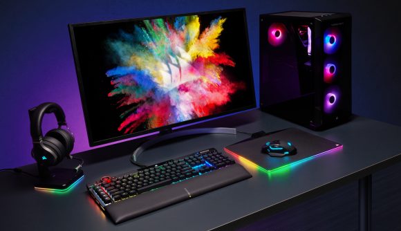 Corsair's K100 RGB gaming keyboard sits next to other peripherals, each shining rainbow RGB lighting