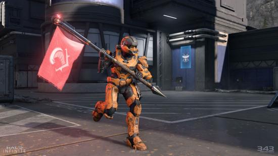 A Spartan in orange armour carries a red flag in Halo Infinite multiplayer.