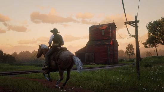 Arthur Morgan rides by a red barn near sundown in Red Dead Redemption 2