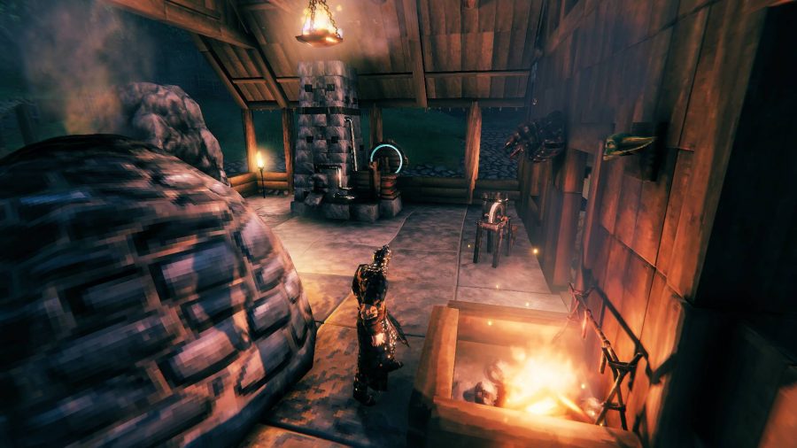 A Viking standing in a forge at night time in Valheim
