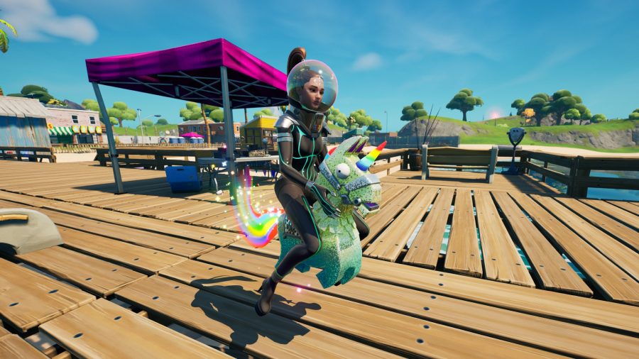 Ariana Grande in a space suit riding a loot llama on the pier