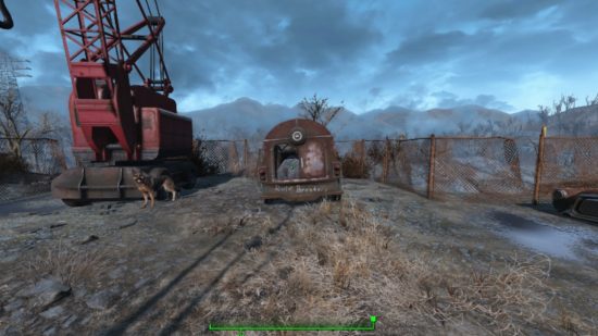 Best Fallout 4 mods: The small container holding crafting supplies beside a crane, while Dogmeat stands guard.