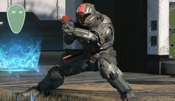 A Spartan from Halo Infinite's multiplayer squats, ready to fire their pistol