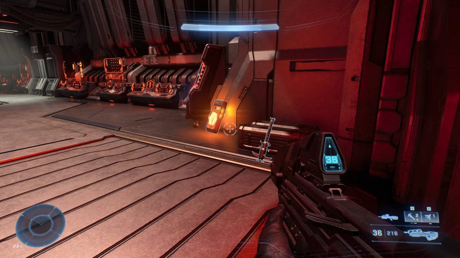 A glowing orange tablet is propped next to a spike grenade. This is a Banished log, one of the Halo Infinite collectibles.