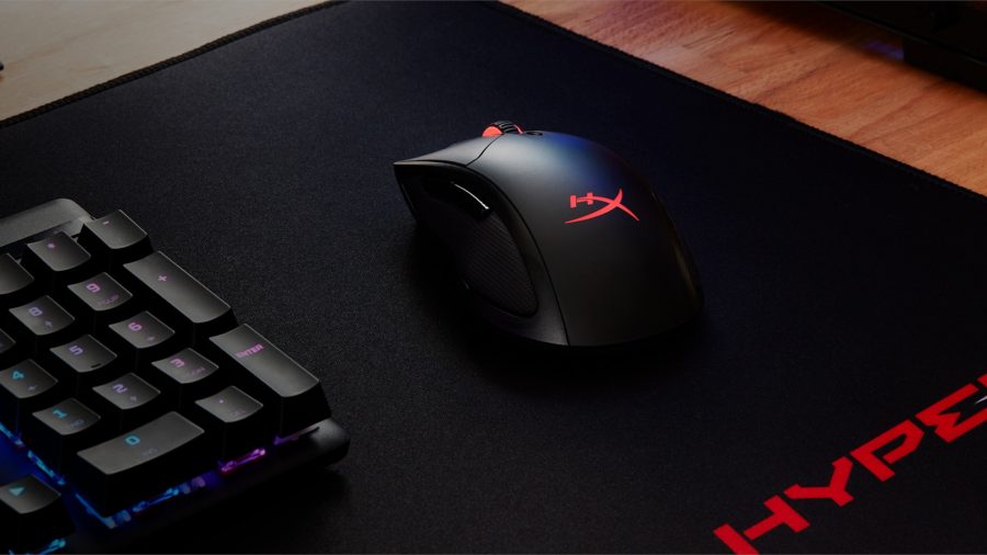 The HyperX Pulsefire Dart wireless gaming mouse, resting atop a black desk mat, surrounded by a gaming keyboard (left)