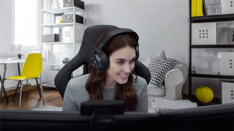 A woman plays on her gaming PC using the Corsair Virtuoso RGB Wireless XT gaming headset