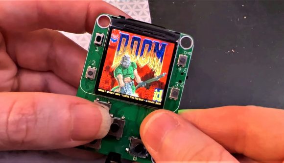 pair of hands holding tiny Doom playing device with title screen