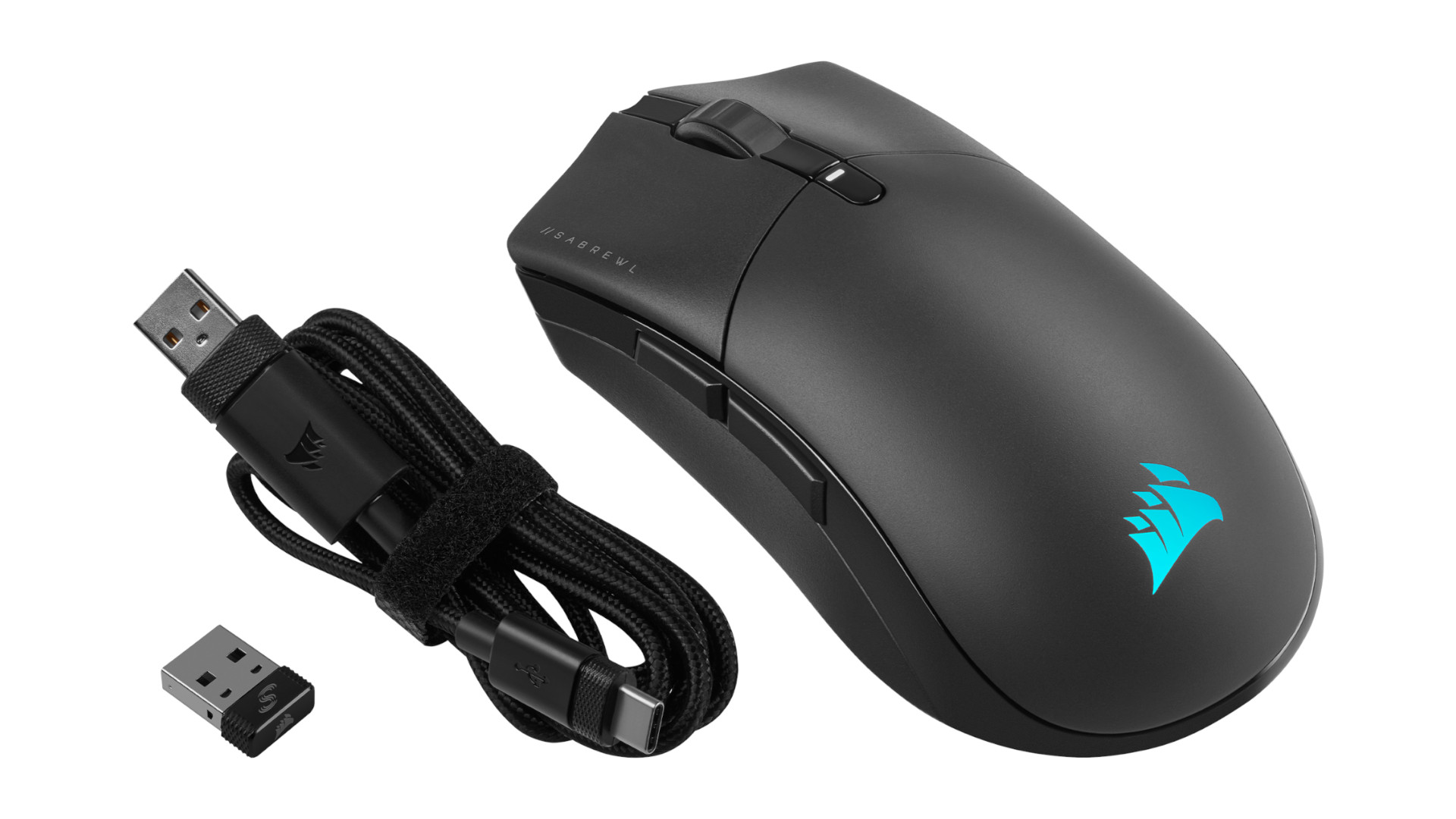La souris de jeu sans fil Corsair Sabre RGB Pro, à côté de son câble de chargement USB-C vers USB-A et de son récepteur USB-A sans fil Slipstream