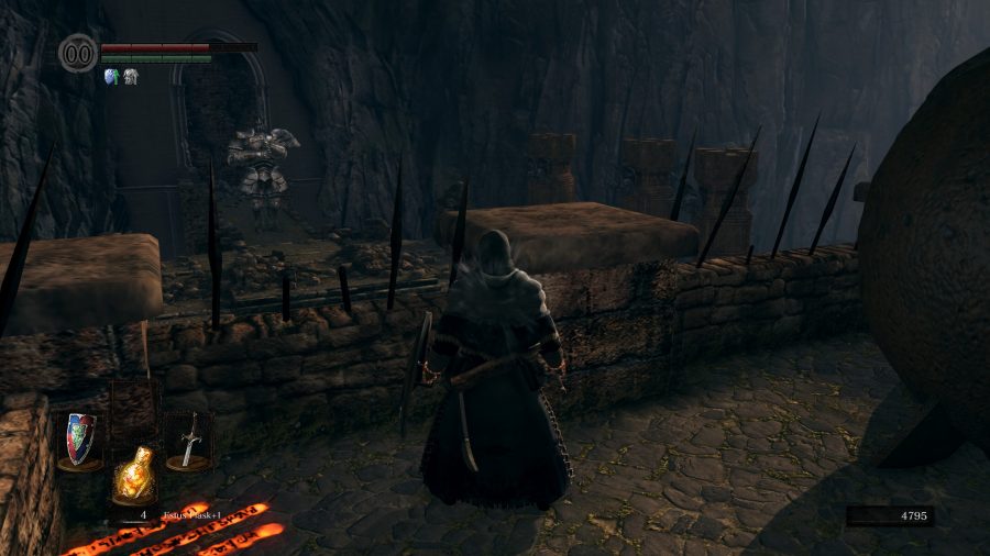 Un guerrier se tient sur un mur de pierre, un golem de fer géant garde une ouverture au loin
