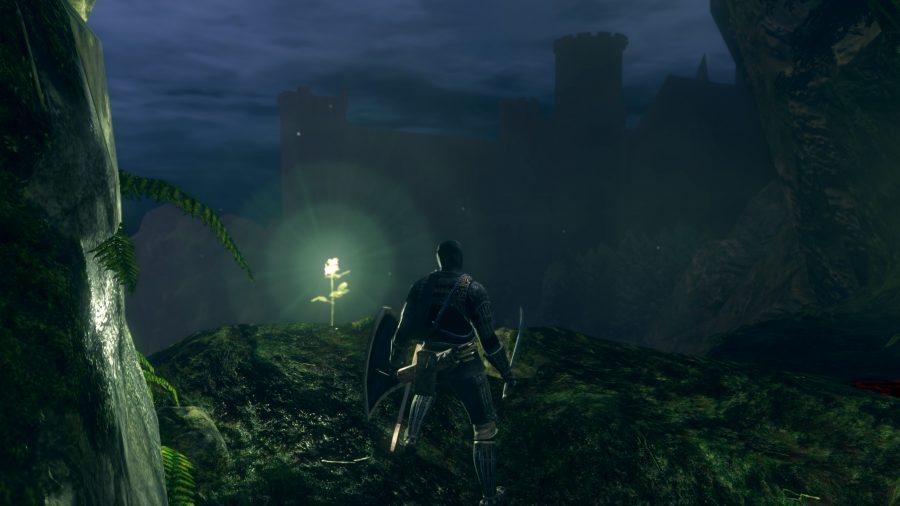 Un homme au bord d'une falaise, un château se dresse au loin enveloppé par l'obscurité