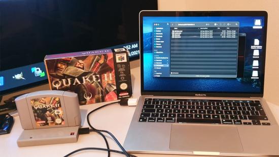 A Quake II N64 cartridge connected to a MacBook