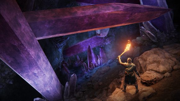 Elden Ring character in cavern with torch lit