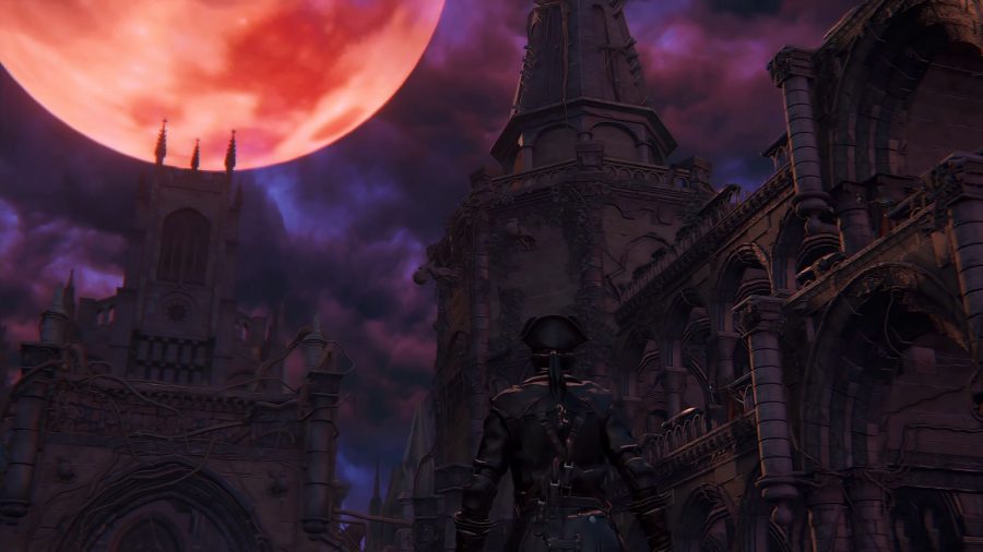 A blood moon illuminates a cathedral courtyard in Bloodborne