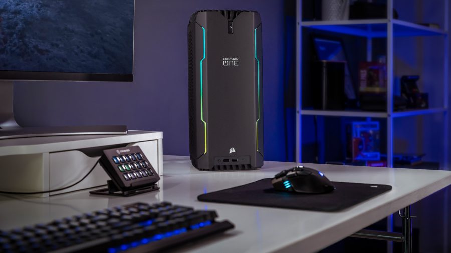The Corsair One i300 gaming computer sits on a white desk, surrounded by an Elgato Stream Deck and other Corsair peripherals